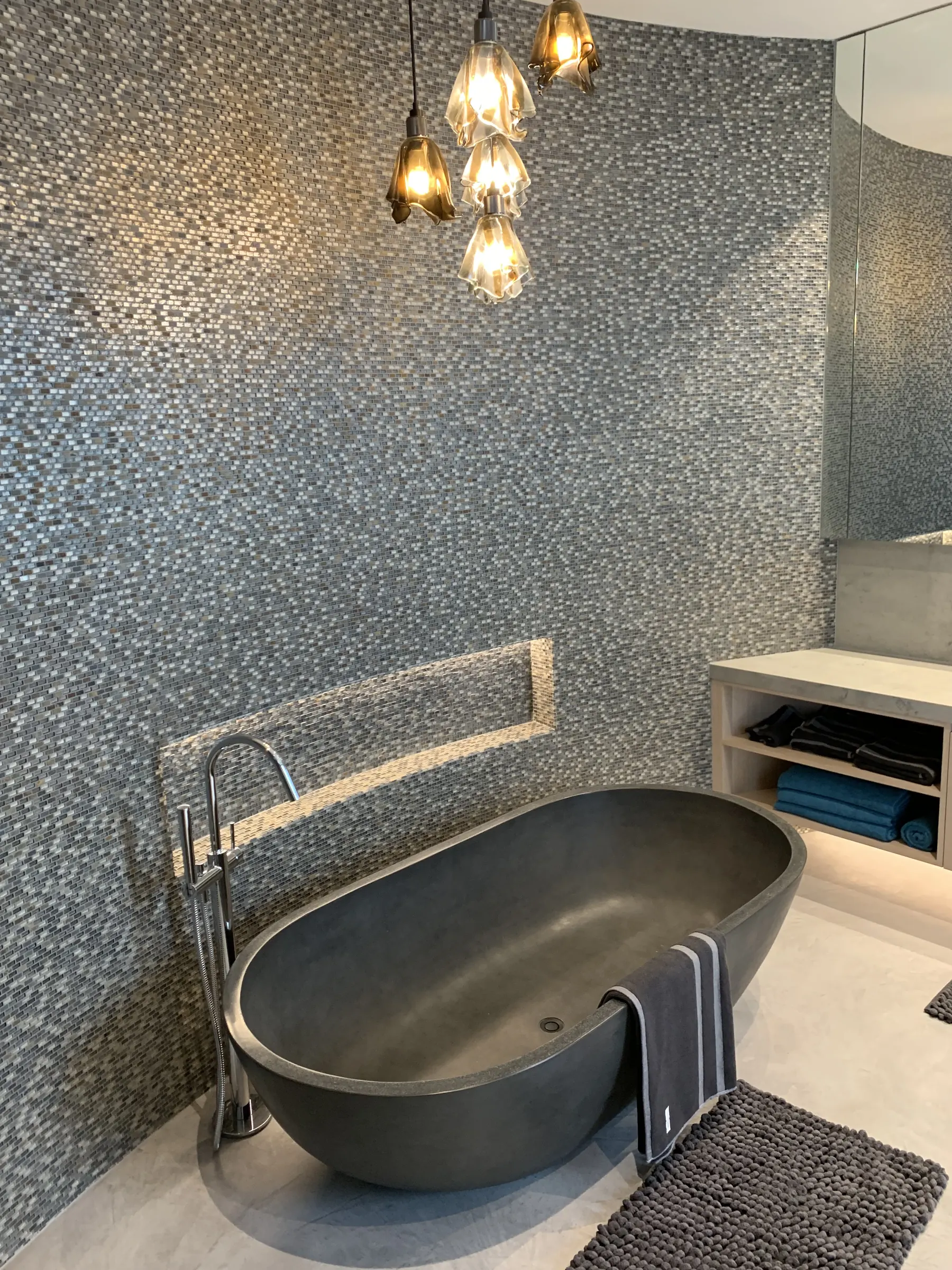 Bathroom with mosaic tile walls, a freestanding bath and pendant lighting