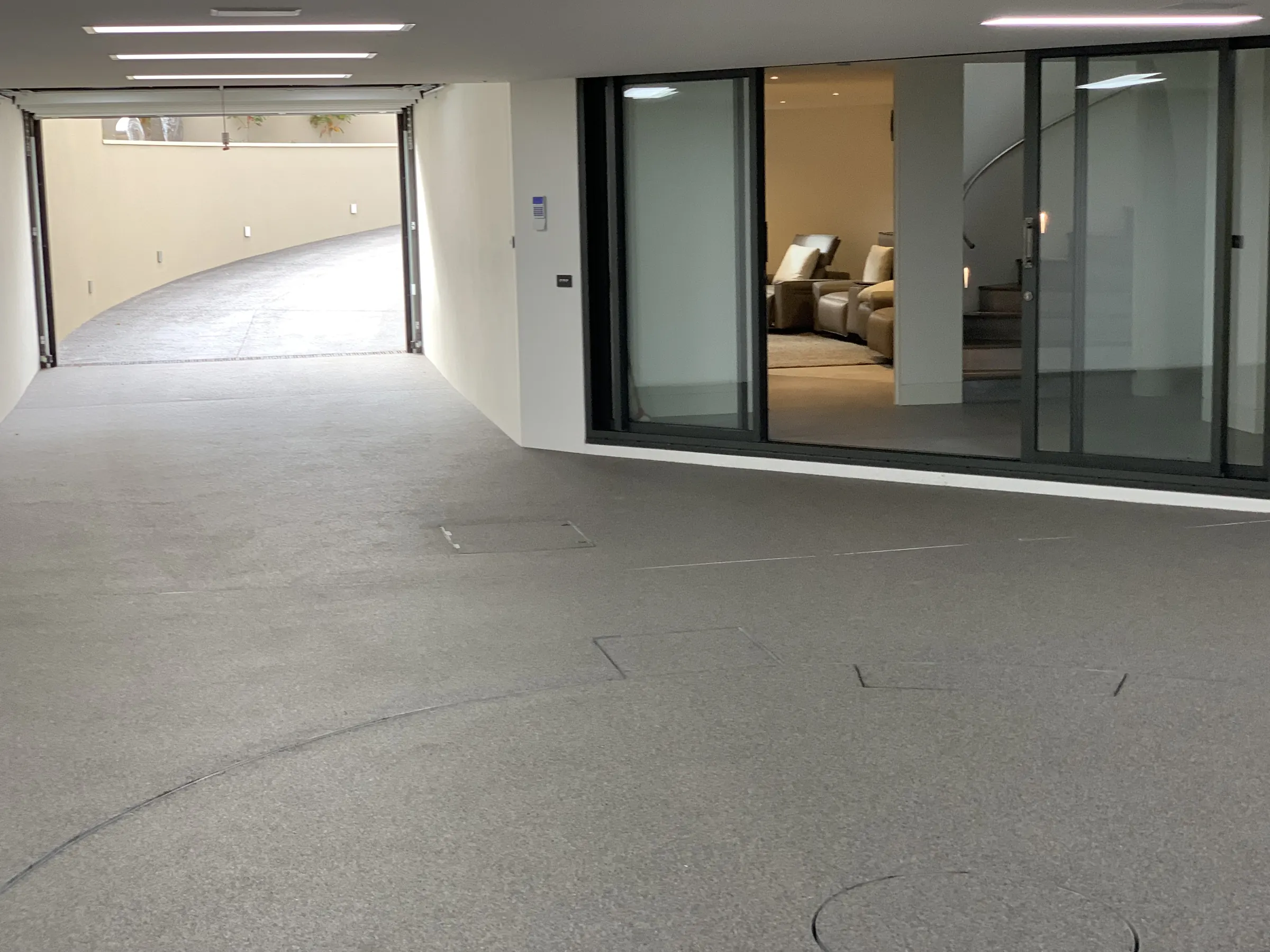 Lower-level garage and living area behind glass sliding doors