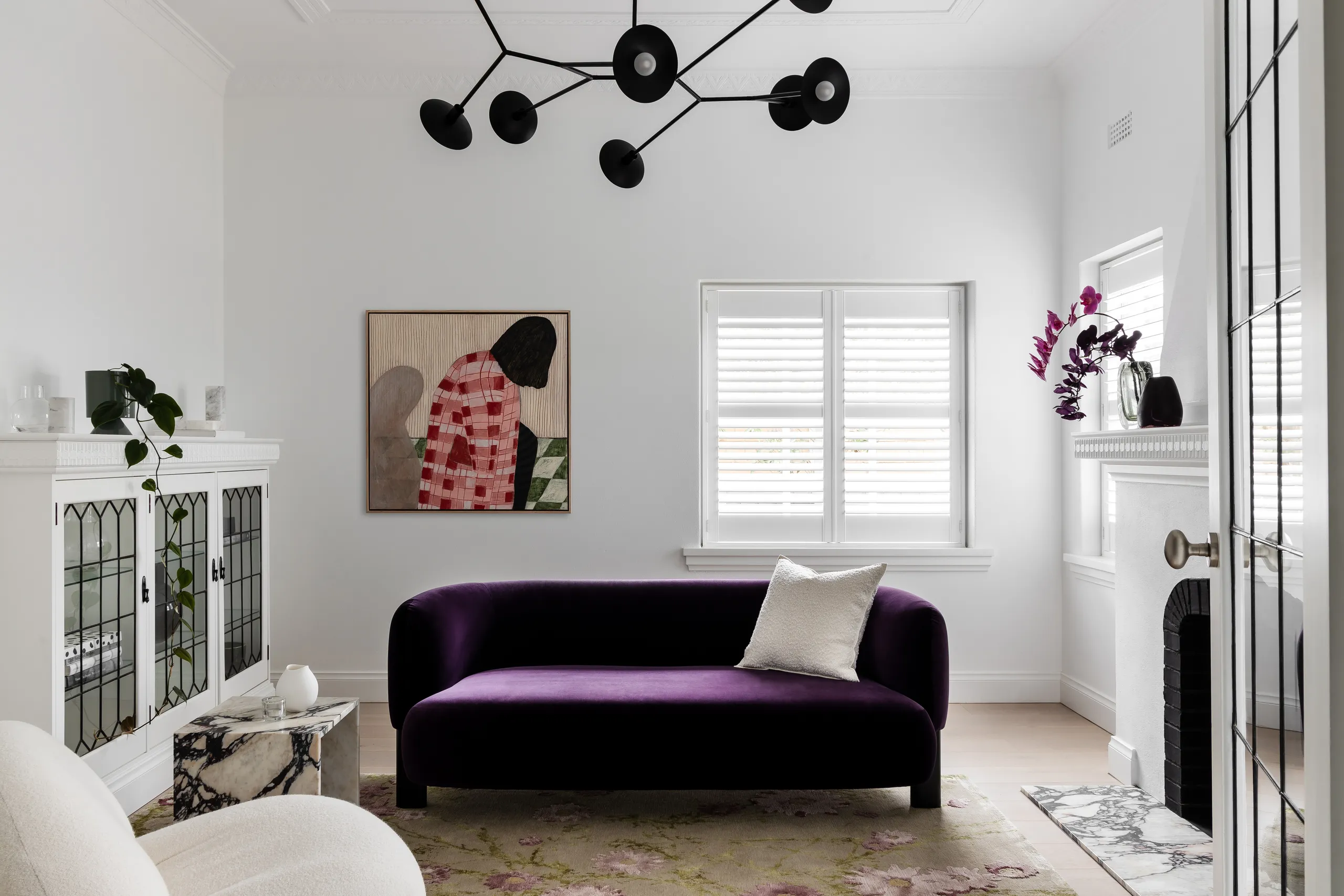 Heritage living room with a velvet sofa, open fireplace and original window joinery