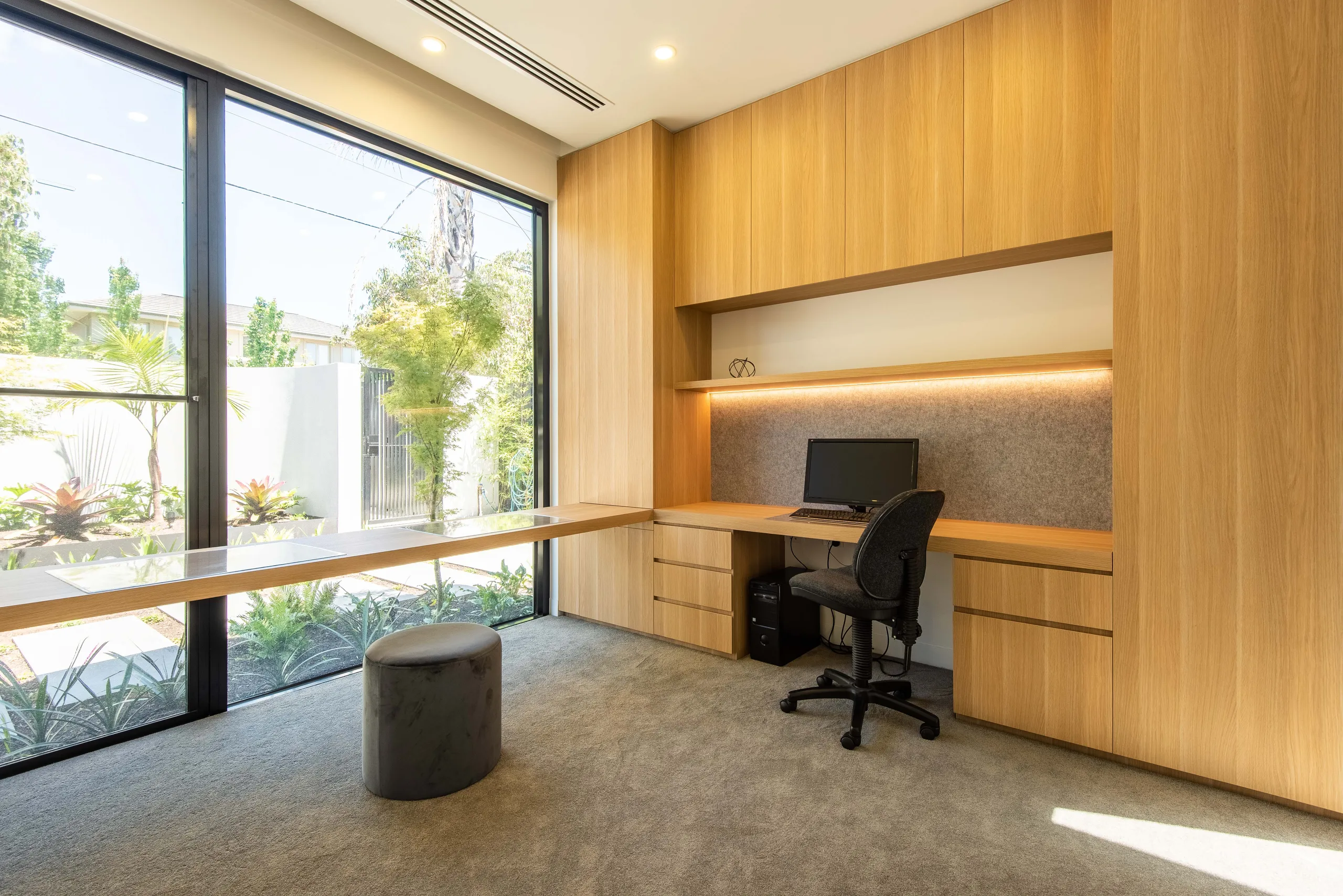 Home office with full-height timber joinery and a window onto the garden