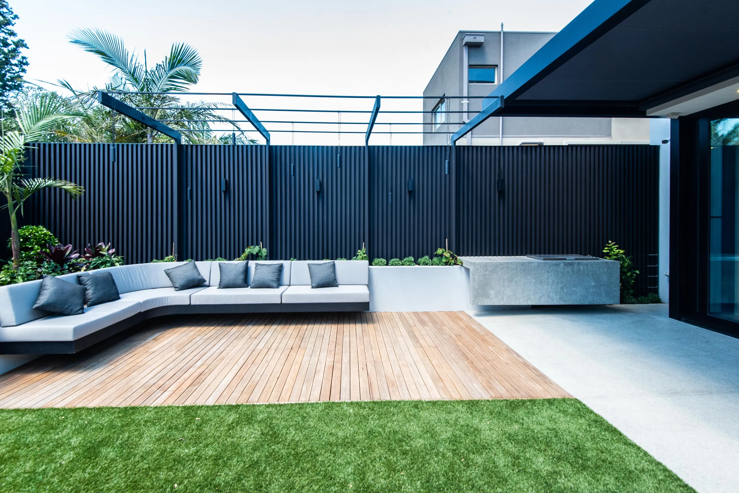Courtyard with a built-in bench seat, timber deck and dark battened screen