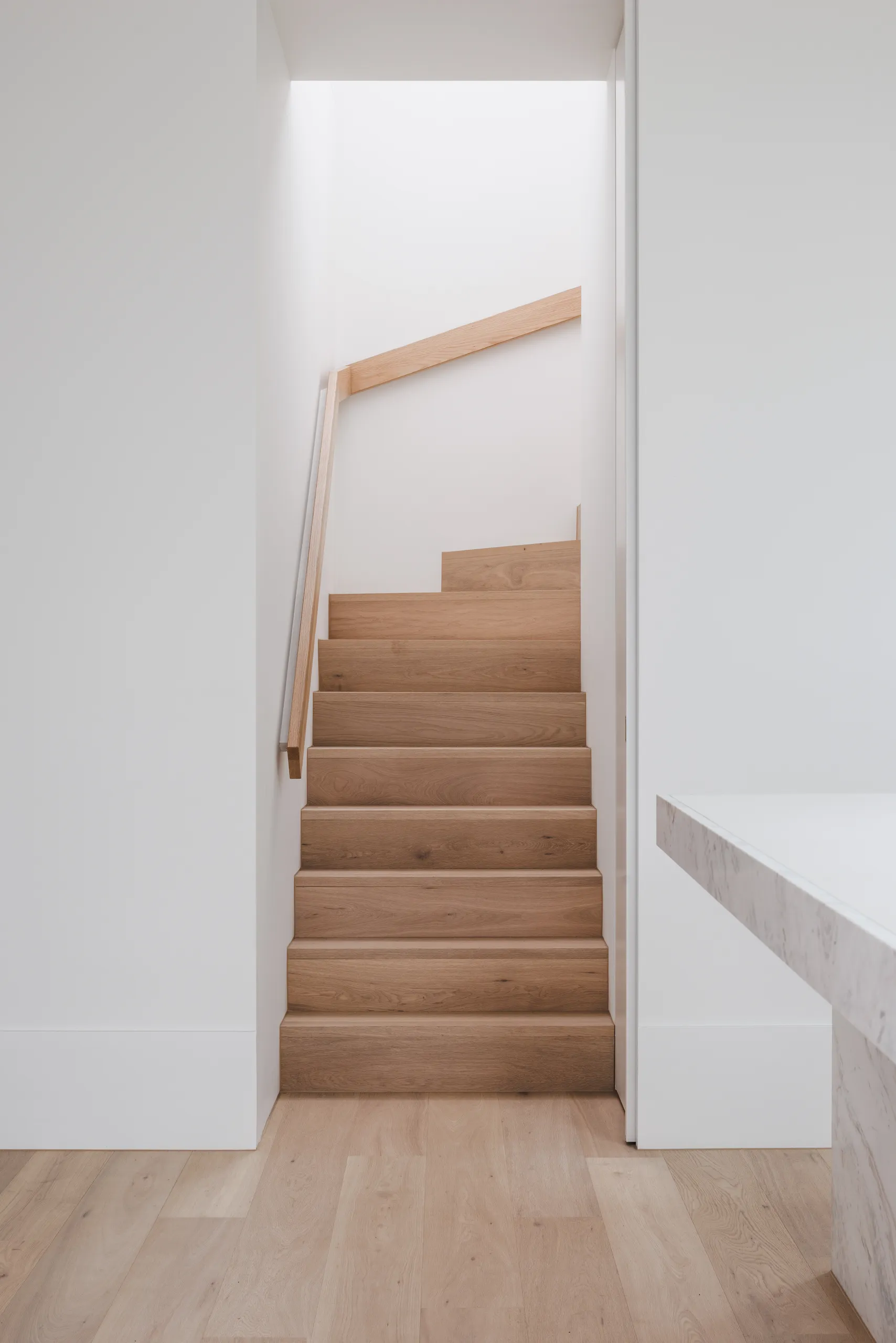 New stair in pale timber rising from the ground floor