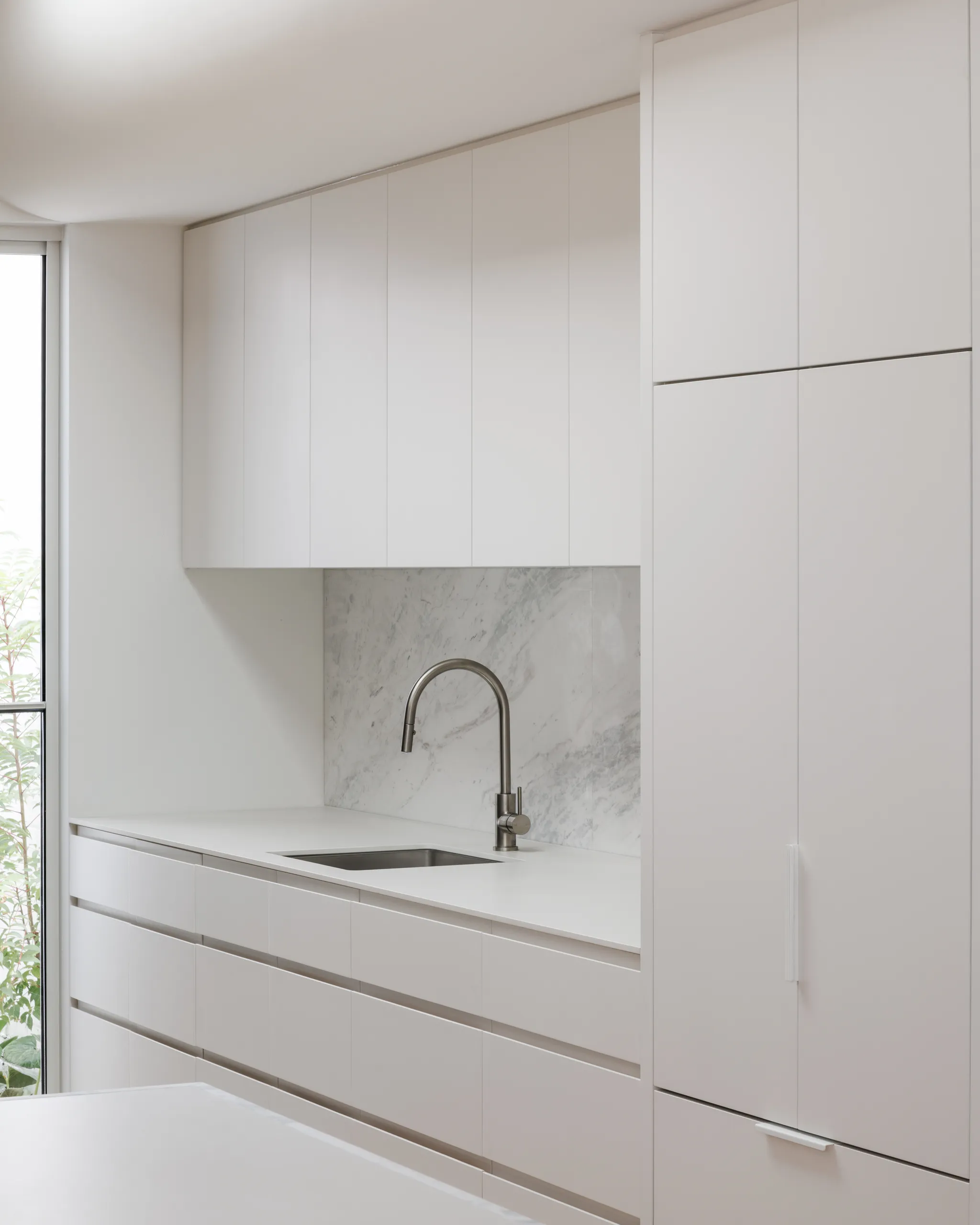 Kitchen bench run with integrated joinery and marble surround